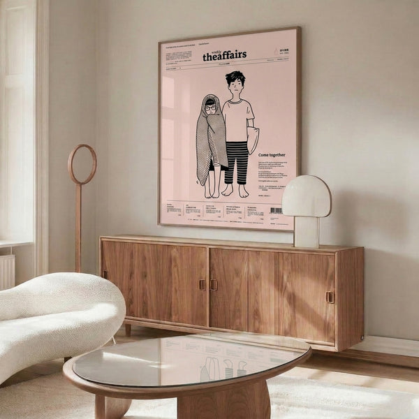Contemporary framed print with spare black linework depicting human figures against blush pink and cream, expressing subtle emotional depth.