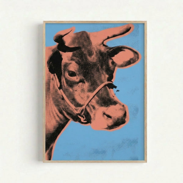 Vibrant contemporary art print with a simplified cow portrait in orange and blue tones, iconic pop art style displayed as framed wall decor.