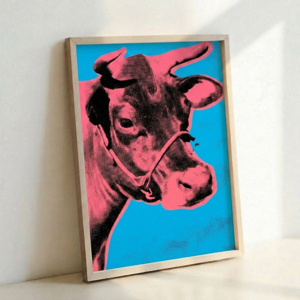 Framed pop art poster showcasing a striking cow design in warm orange hues set against cool blue, bold and energetic modern aesthetic.