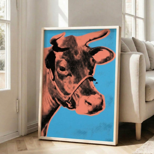 Orange cow silhouette pop art print on blue background, contemporary framed poster with bold graphic impact and minimalist composition.