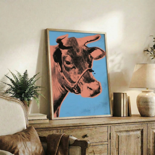 Modern pop art framed print featuring a stylized bovine face in bright orange and electric blue, eye-catching minimalist wall art.