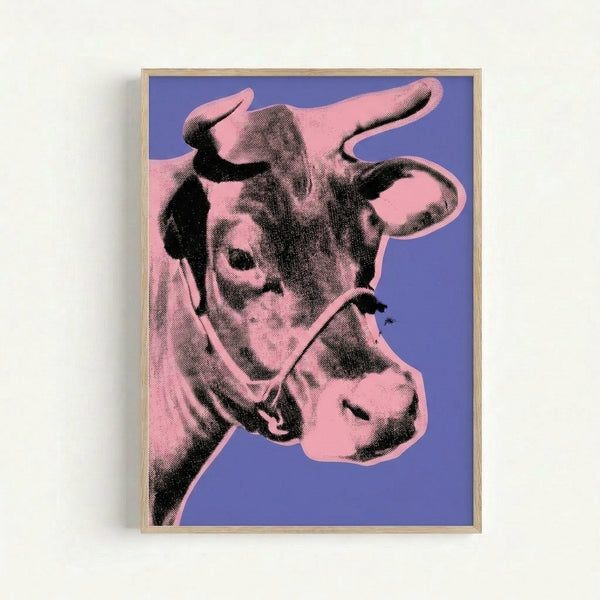 Framed art print of a stylized cow portrait rendered in bright pink tones on deep purple, exemplifying contemporary pop art aesthetics.