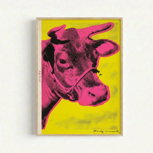 Framed modern art print with a bold pink cow illustration on sunny yellow, characteristic of 1960s pop art style.
