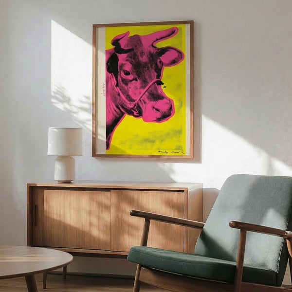 Trendy pop art wall piece featuring a minimalist pink cow silhouette positioned against a bold yellow ground.