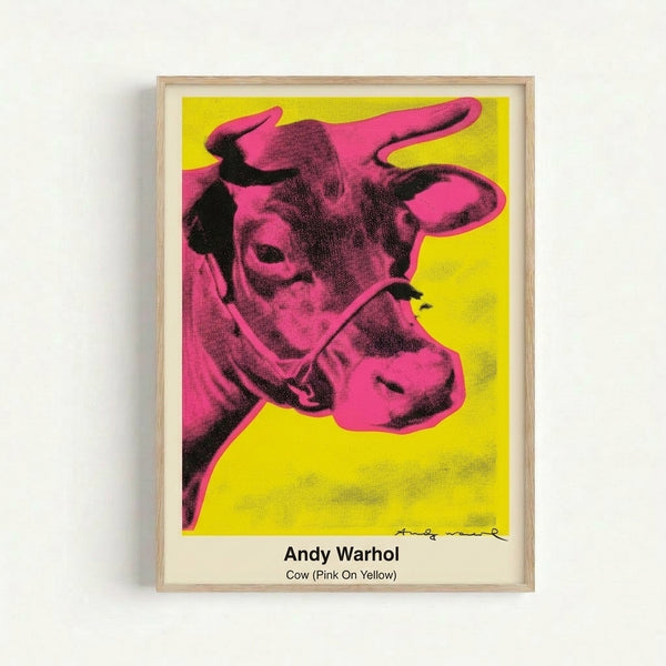 Framed modern art print showcasing a playful pink cow portrait in pop art style with striking yellow field and graphic black lines.