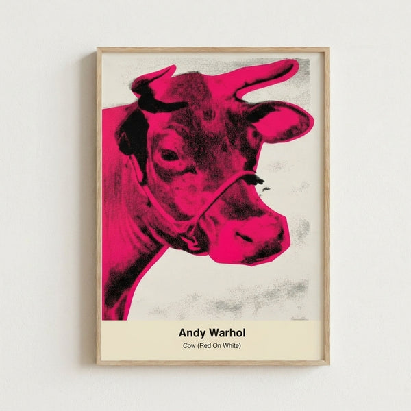 Vibrant red cow portrait with black outlines and white negative space, striking pop art style wall print in a contemporary interior.