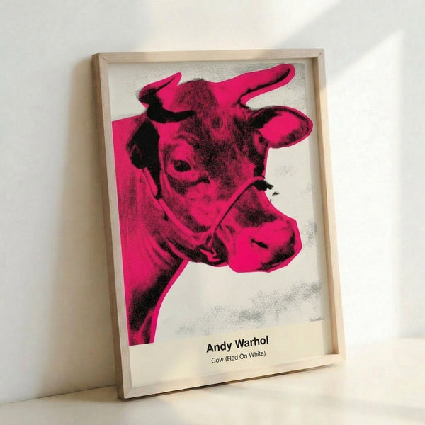 Pop art cow illustration in vivid red and white with thick black contours, a subversive kitsch masterpiece displayed as a framed poster.