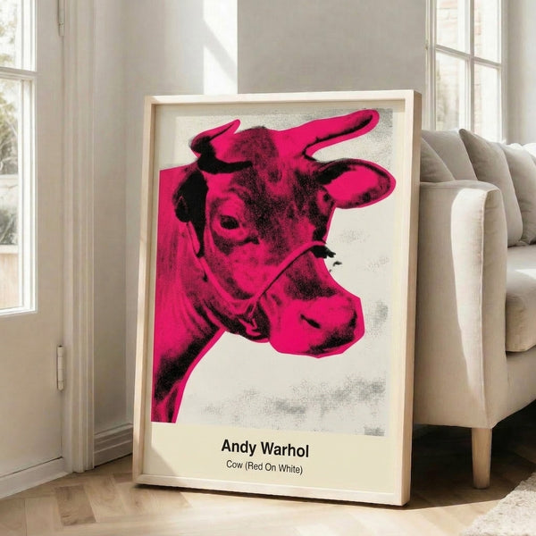 Minimalist pop art cow head rendered in red and white with bold graphic lines, modern art print hanging on a wall.