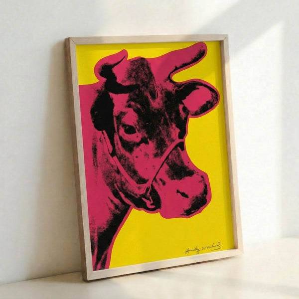 Contemporary art print with a simplified cow head in crimson red on warm yellow, embodying bold pop art aesthetics.