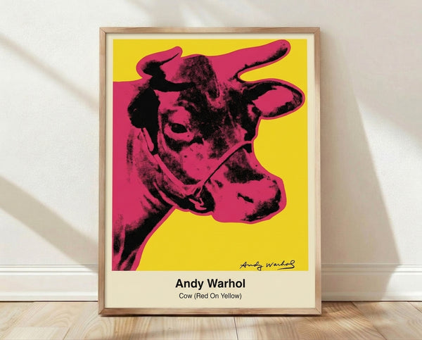 Bold pop art poster featuring a cow's head in vibrant red and yellow with black outlines, rendered in the iconic Warhol style on a white background.