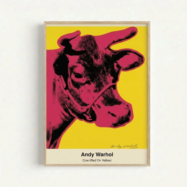 Framed modern art print of a stylized cow portrait in red, yellow, and black, showcasing playful pop art aesthetics with Bauhaus-inspired geometric simplicity.