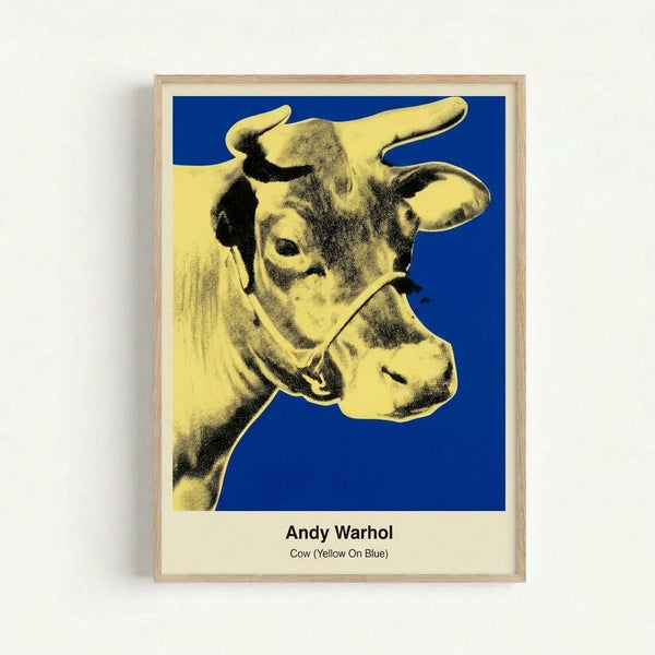 Framed pop art print of a cow rendered in striking yellow and hot pink tones on electric blue, capturing the irreverent energy of 1960s pop art movements.