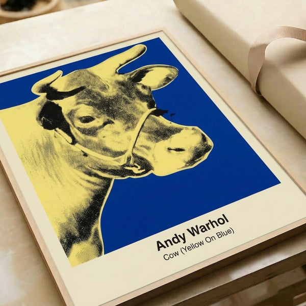 Bright pop art cow head framed poster featuring yellow and magenta coloring on electric blue background, a witty celebration of kitsch and color saturation in modern art.