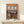 Vintage-inspired poster of a cozy bookstore storefront rendered in soft blues, warm oranges, and natural wood tones with potted greenery framing the windows.