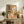 Peaceful framed poster of a Japanese-inspired coffee preparation space with greenery, window light, and warm lighting, executed in soft beige, terracotta orange, and forest green hues.