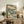 Framed poster of a solitary crane gliding among clouds in the Japanese woodblock tradition, combining serene brushwork with a sophisticated color scheme of teal, cream, rust, and gold.