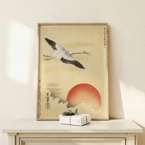Minimalist Japanese crane woodblock artwork showing a bird in graceful flight with a bold red sun backdrop, mounted as a framed wall print.