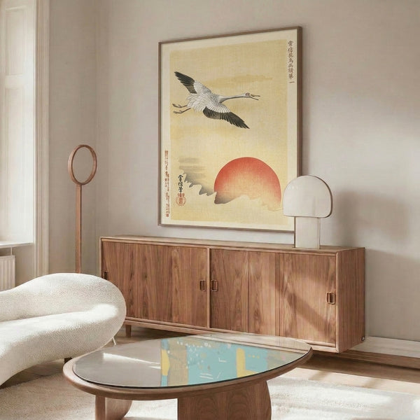 Serene bird print showing a crane in flight toward a glowing red sun, executed in traditional style with cream, gray, black, and tan palette.
