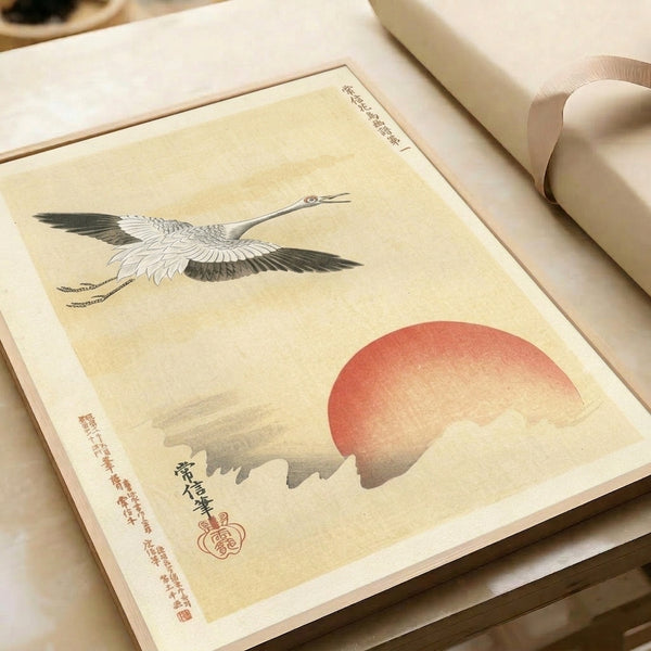 Framed Japandi wall art of a graceful crane ascending toward a bold red solar orb, rendered with minimalist woodblock sensibility and calm sophistication.