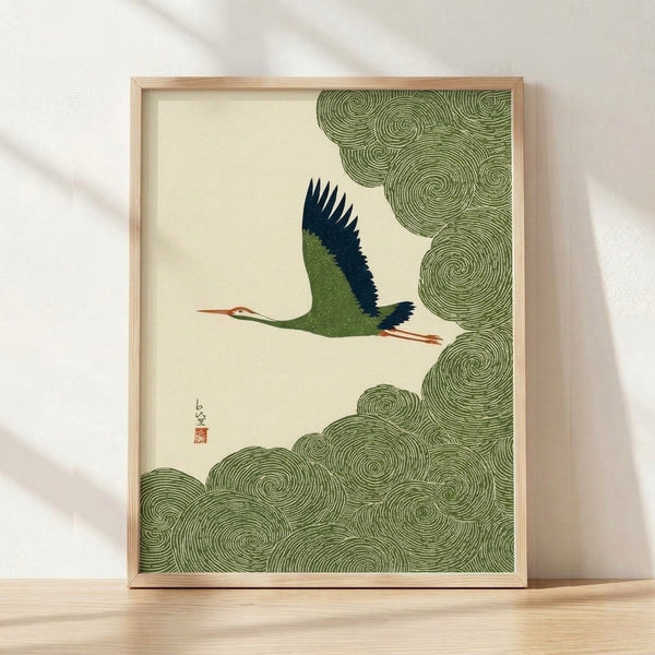 Serene Japanese woodblock-style crane art print with minimalist clouds in cream, forest green, and navy tones, framed on wall in Japandi aesthetic.