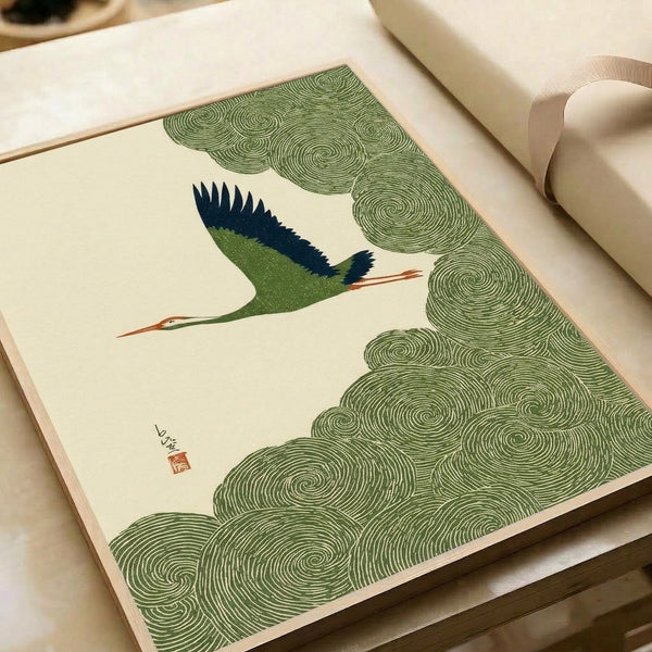 Framed Japanese woodblock crane print with navy and sage clouds in serene, contemplative style; calming Japandi decor with terracotta and cream tones.