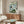 Japandi wall art featuring a graceful crane amid water and reeds in a minimalist composition, dominated by calming sage green and pale blue tones with cream and black details.