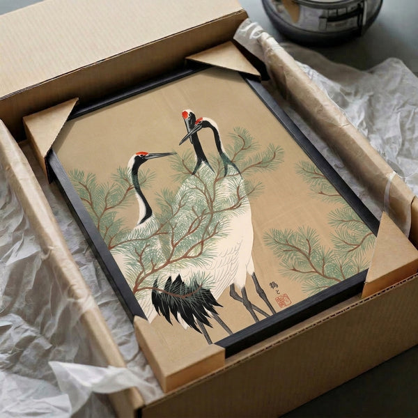 Serene Japanese crane and pine woodblock art print with cream background, black linework, and accents of muted green, red, and brown tones on a framed wall display.