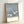 Peaceful framed art print showing cranes in a snowy woodland scene, executed in Japanese woodblock technique with muted palette of slate blue, white, and dark navy.