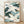 Serene Japanese woodblock-style poster of flying cranes in cream, forest green, and slate blue tones with gold accents, framed on a wall.