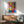 Abstract art print showing a dancing figure in bold primary hues and warm tones, rendered with flowing cut-out forms that convey energetic, jubilant movement.