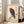 Minimalist Japanese crow painting featuring a single bird on a tan and charcoal rock formation, calm and meditative in composition.