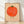 Whimsical folk art poster of a cheerful tomato character with a smiling face, rendered in coral red, sage green, and cream tones in a minimalist cottagecore style, framed on a wall.