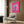 Pop art style daisy poster rendered in warm pink tones with radiant yellow center, cheerful modern flower artwork for wall décor.