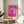 Framed artistic print featuring a stylized daisy in luminous pink and magenta tones with yellow center detail, embodying bold pop art sensibility and contemporary floral design.