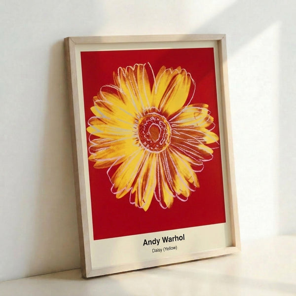 Framed pop art print of a daisy flower in vibrant yellows, pinks, and greens with bold graphic lines and abstract composition.