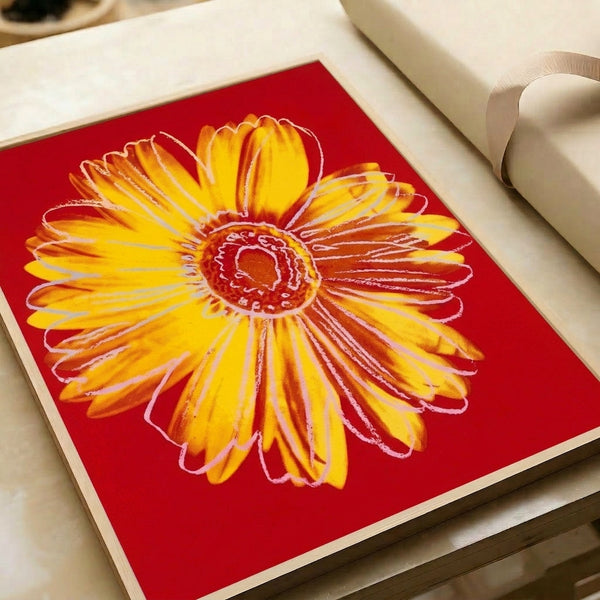 Pop art style daisy flower with vivid yellow petals and layered colors in a framed poster hanging on wall.