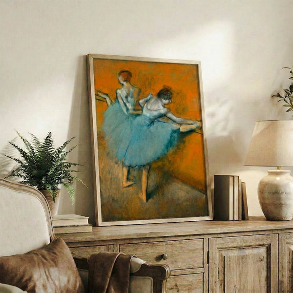 Framed print of elegantly posed dancers practicing at the barre, rendered in soft impressionist tones with an air of serene concentration.