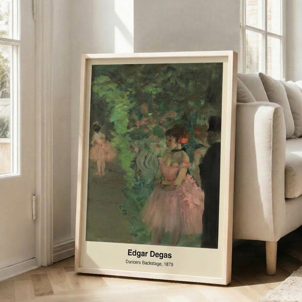 Framed impressionist print featuring ballet dancers adjusting their costumes and resting in ochre, grey, and cream, capturing an unguarded theatrical moment.