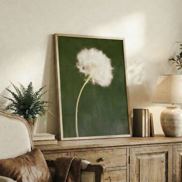 Peaceful nature-inspired framed poster of a dandelion seed head rendered in muted sage green and cream, creating a meditative wall display.