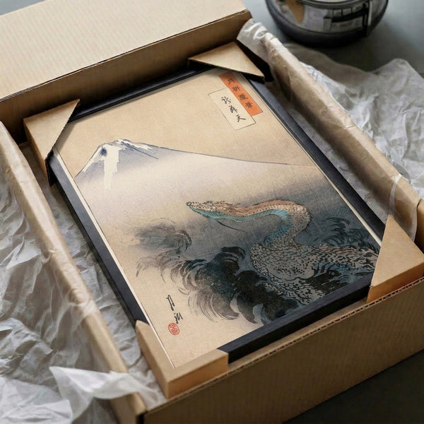Mythical dragon ascending past Mount Fuji through billowing clouds in this framed Japanese woodblock-style print, composed in serene cream, blue-grey, and rust orange tones.