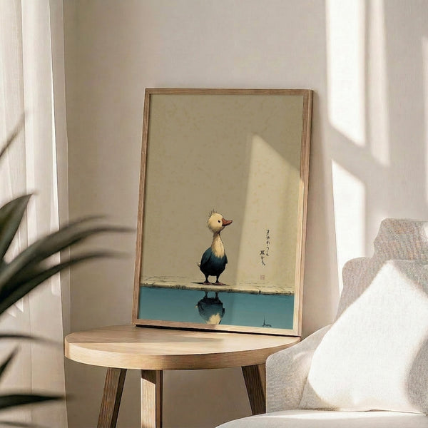 Calm and contemplative framed poster showing a duckling in profile with its reflection below, drawn in elegant black lines on cream background with teal and ochre accents.