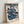 Refined Japanese woodblock art print featuring a geisha in deep indigo robes with coral highlights, a child attendant, and cherry blossom motifs creating an elegant, timeless aesthetic on framed wall art.