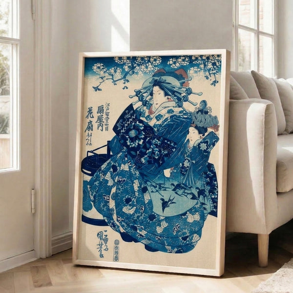 Framed Japanese woodblock-inspired artwork of a poised geisha wearing navy and cream kimono, holding a fan with birds and flowers in elegant composition.