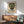 Wall art poster showcasing a geometric Bauhaus interpretation of a ceremonial Mexican mask with elaborate beading and necklace in earthy rust and sage hues.