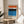 Calm, contemplative poster art with simple blue and orange geometric shapes on neutral background, framed on wall.