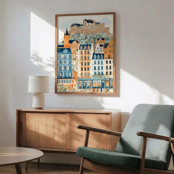Charming cottagecore watercolor illustration of Edinburgh's castle district street scene with vintage buildings, tower, and blooming flowers in muted cream and orange hues, framed as poster art.