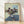 Abstract figure in muted earth tones and grays, depicted writing while viewed through a mirror reflection, framed poster art in contemplative expressionist style.