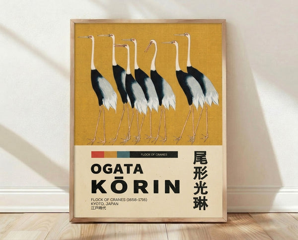 Framed Japanese woodblock print depicting a graceful flock of cranes in flight, rendered in gold, black, and cream tones with serene elegance characteristic of Ogata Korin's style.
