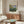 Contemplative impressionist painting of flower beds in luminous orange, green, and blue, capturing the tranquil essence of a flowering garden landscape.