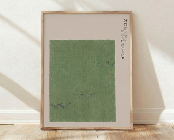 Serene Japanese woodblock poster featuring birds in flight over a minimalist temple landscape in sage green, cream, and charcoal tones, framed on a wall.